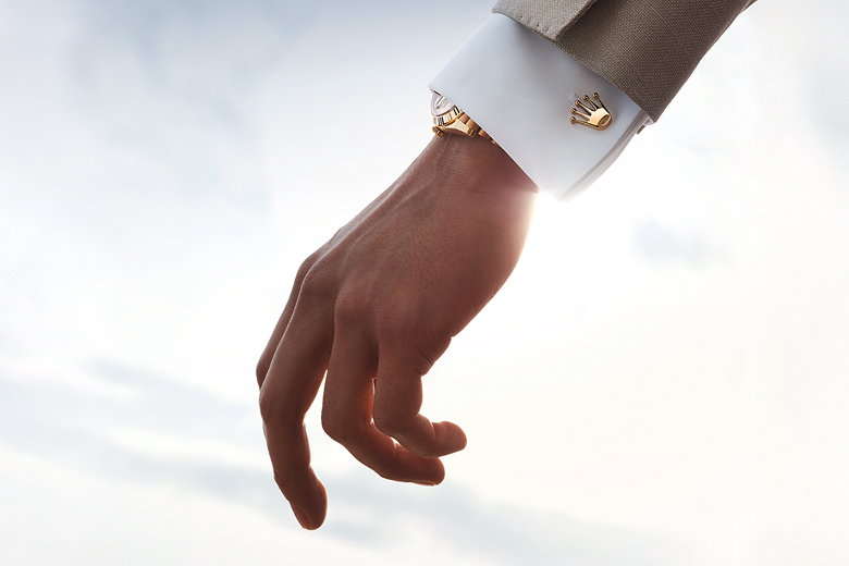 A hand showing the Rolex cufflinks